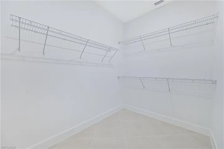 Walk in closet with light tile patterned floors