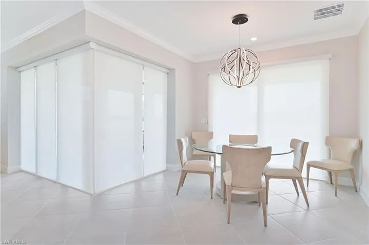 Dining area featuring ornamental molding and a chandelier