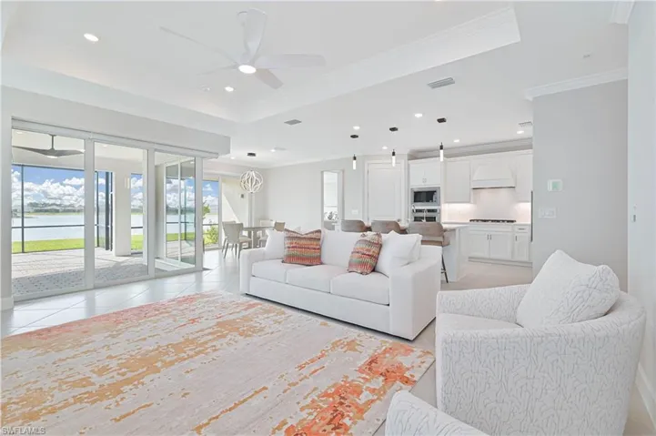 Living room with a water view, recessed lighting, crown molding, and ceiling fan