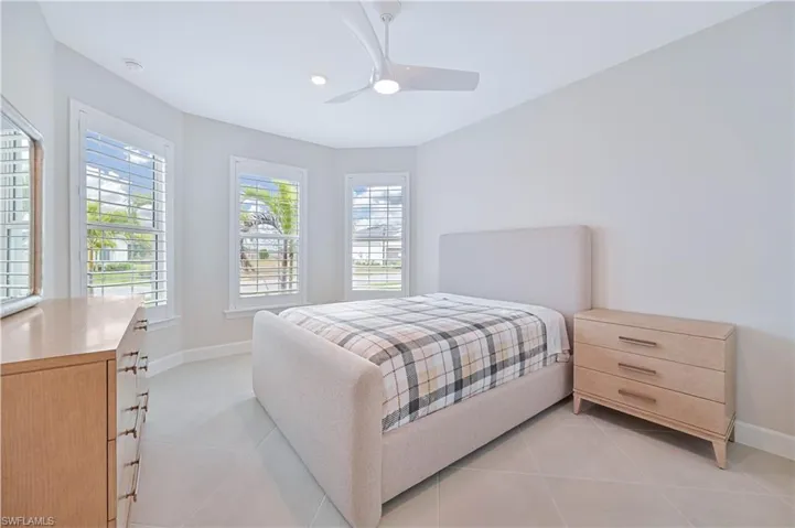 Bedroom with ceiling fan and light tile patterned floors
