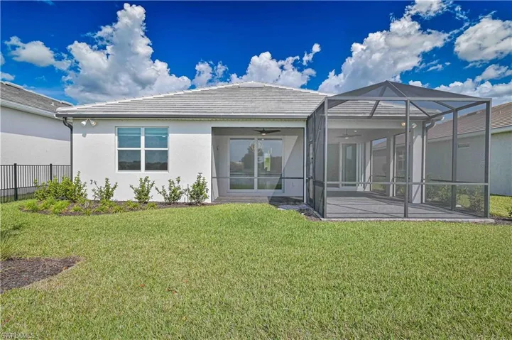 Back of house featuring ceiling fan, stucco siding, a sunroom, a tiled roof, and a lanai