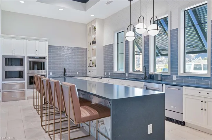 Kitchen featuring a kitchen bar, a large island, stainless steel appliances, tasteful backsplash, and recessed lighting