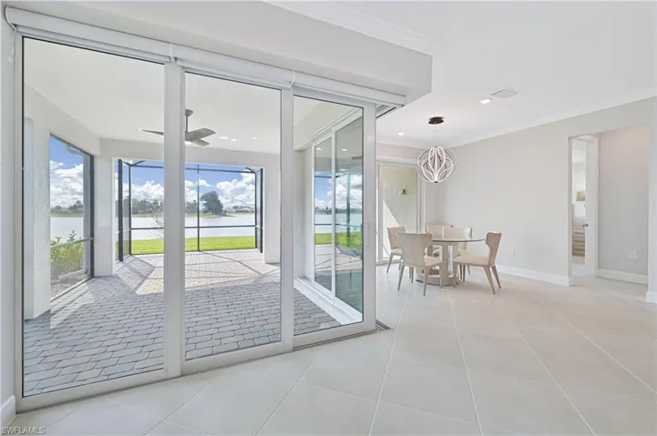 Entryway featuring crown molding, a water view, tile patterned floors, a ceiling fan, and recessed lighting