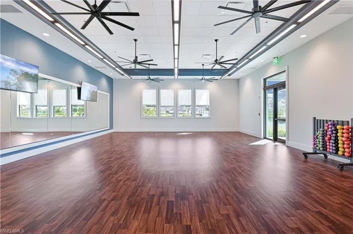 Unfurnished living room featuring plenty of natural light, dark wood-type flooring, and recessed lighting