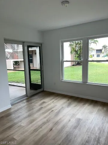 Unfurnished room with healthy amount of natural light and wood finished floors
