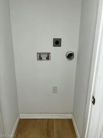 Washroom with electric dryer hookup, wood finished floors, and hookup for a washing machine