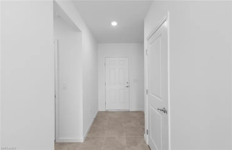 Hall with baseboards and light tile patterned floors