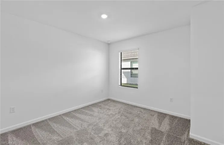 Empty room featuring baseboards and light colored carpet