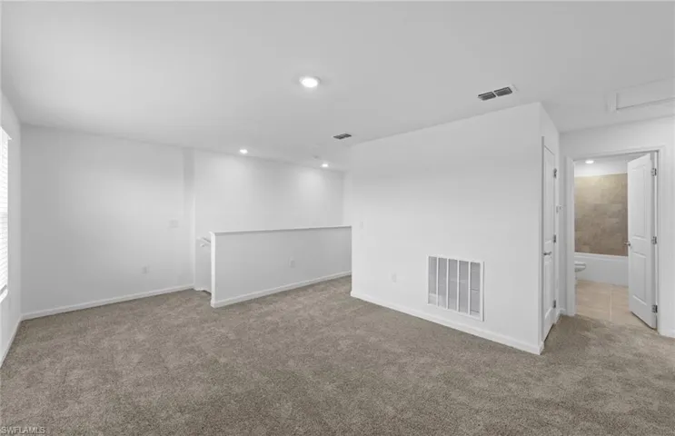 Carpeted empty room featuring baseboards and recessed lighting