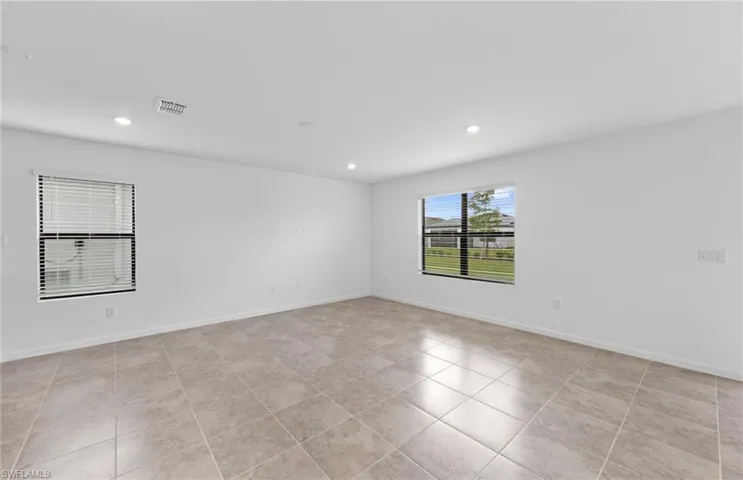 Unfurnished room with recessed lighting and baseboards