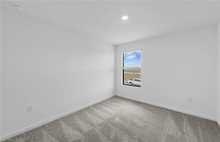 Empty room with baseboards and light carpet