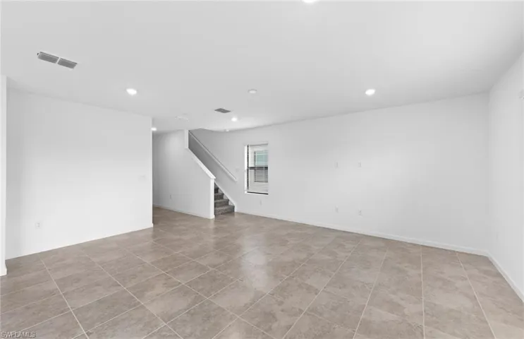Empty room with recessed lighting and light tile patterned floors