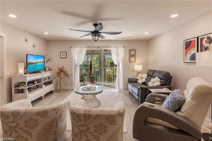 Living room with baseboards, a ceiling fan, recessed lighting, and wood finished floors