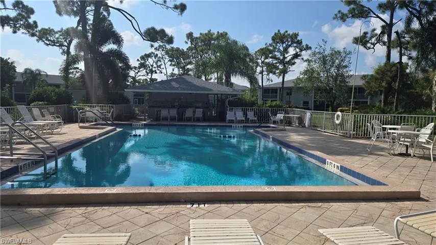 Community pool featuring a patio and fence