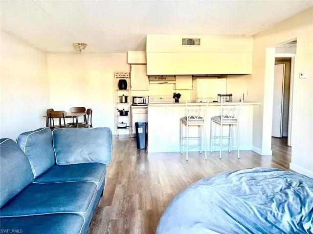 Living area with light wood finished floors and a textured ceiling