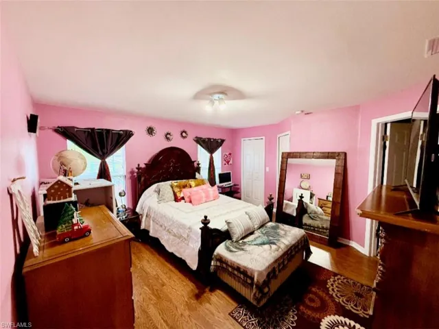 Bedroom with wood finished floors and a closet