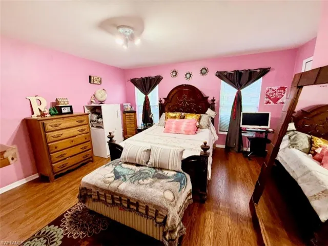 Bedroom featuring multiple windows and wood finished floors