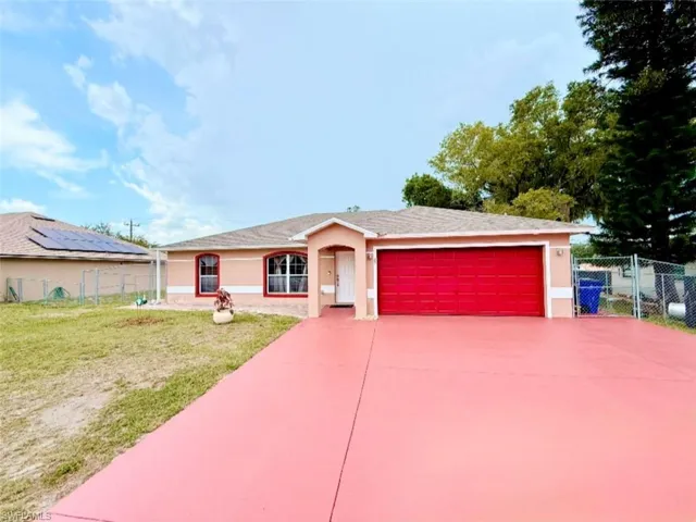 Ranch-style house with stucco siding, a garage, and driveway