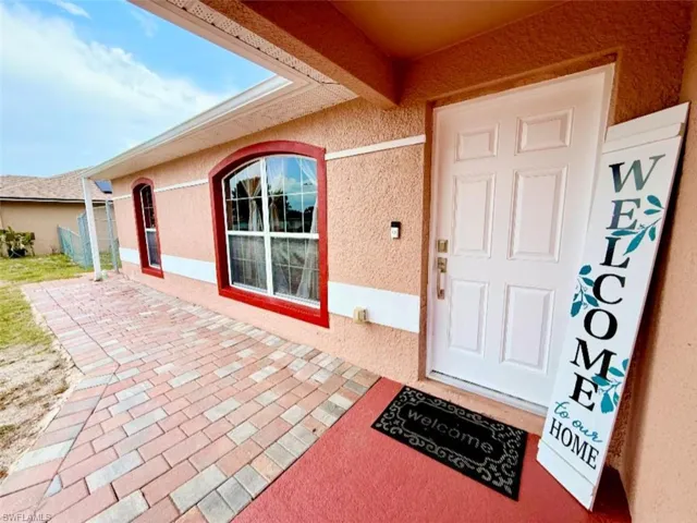 Doorway to property featuring stucco siding and a patio