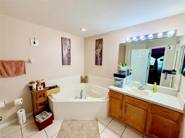 Bathroom featuring vanity, a garden tub, and tile patterned floors