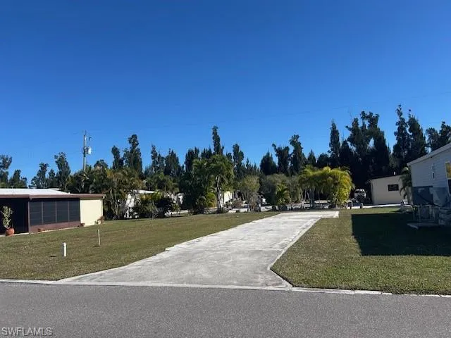 View of community featuring a lawn and view of scattered trees