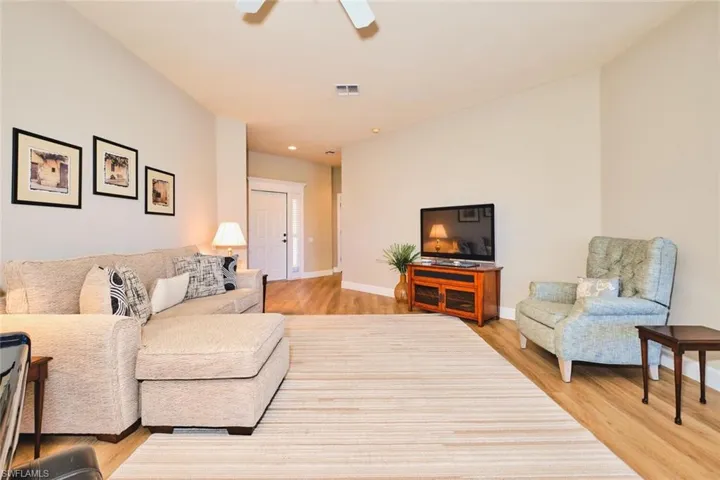 Living area featuring light wood-style floors, baseboards, ceiling fan, and recessed lighting