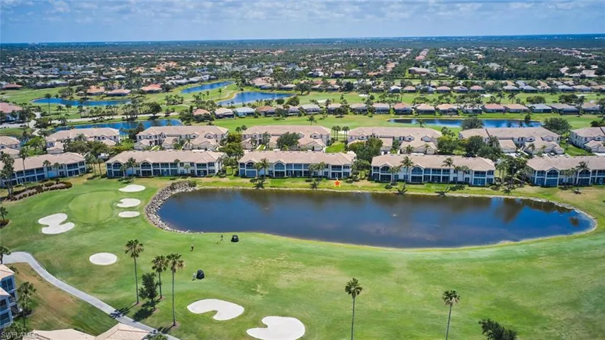 Aerial overview of property's location featuring a large body of water, nearby suburban area, and a golf course