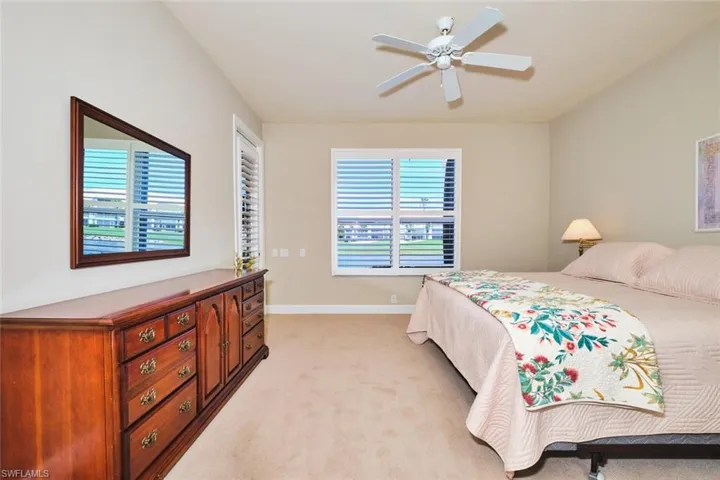 Bedroom with light carpet, baseboards, and ceiling fan