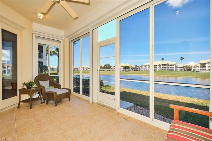 Sunroom / solarium featuring tile patterned flooring and a water view
