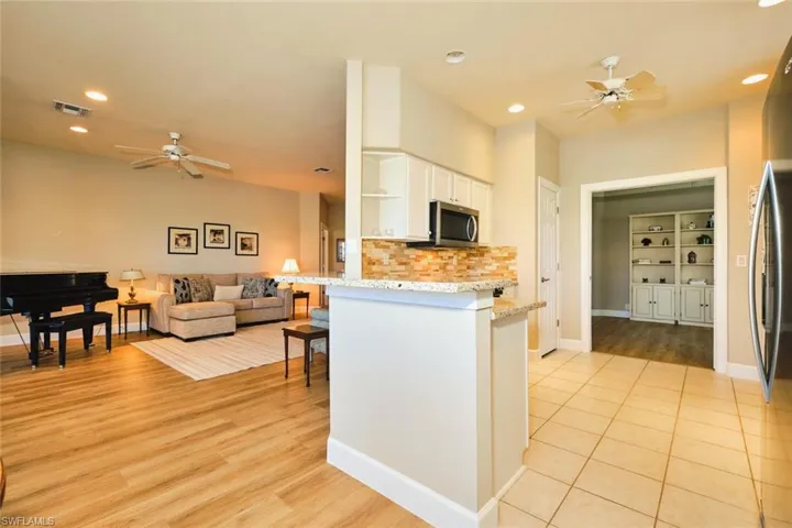 Kitchen with ceiling fan, appliances with stainless steel finishes, open shelves, white cabinets, and recessed lighting