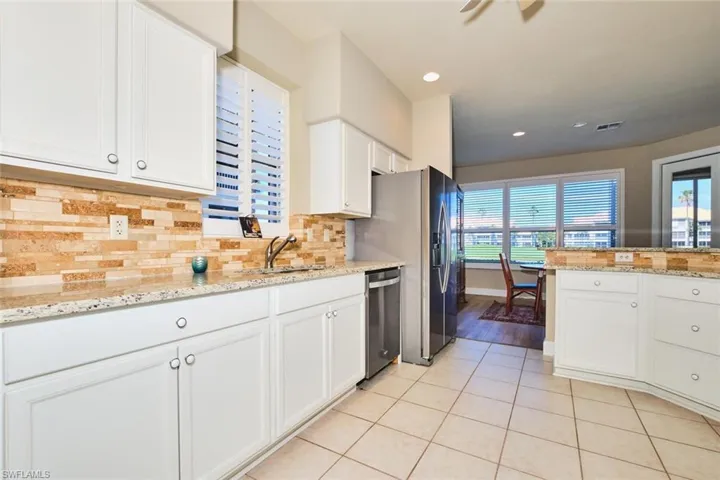 Kitchen featuring stainless steel appliances, healthy amount of natural light, white cabinetry, light tile patterned flooring, and recessed lighting