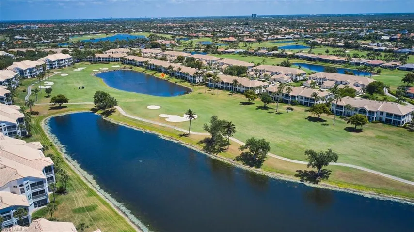 Aerial perspective of suburban area with a nearby body of water and a golf course