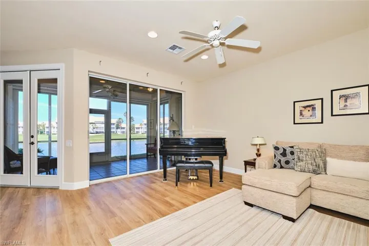 Living area with a ceiling fan, baseboards, wood finished floors, and recessed lighting