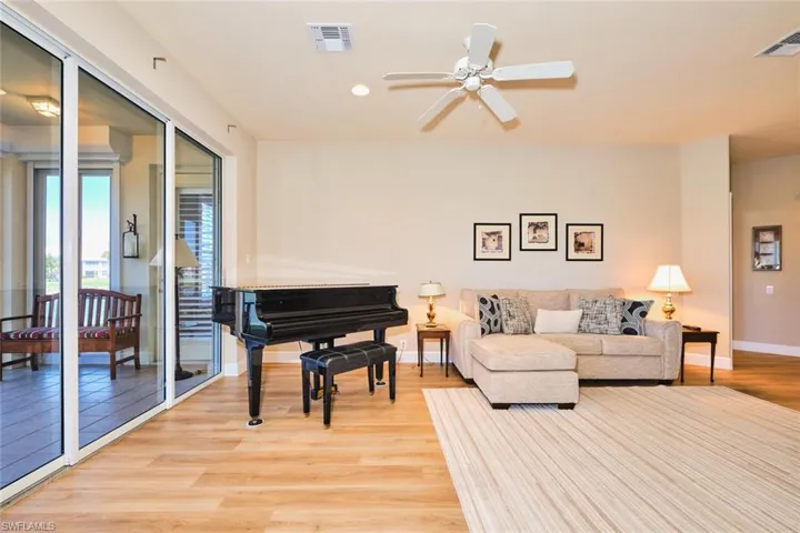 Living area featuring light wood-type flooring, baseboards, a ceiling fan, and recessed lighting