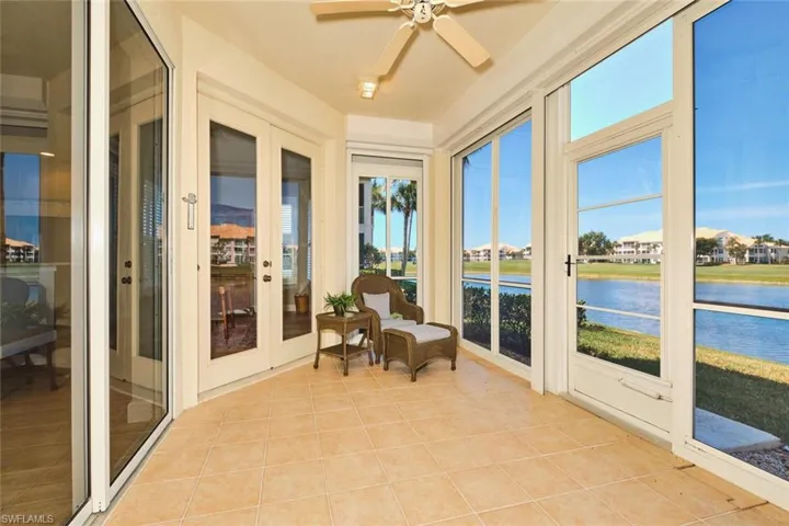 Sunroom / solarium featuring tile patterned floors, a water view, and french doors