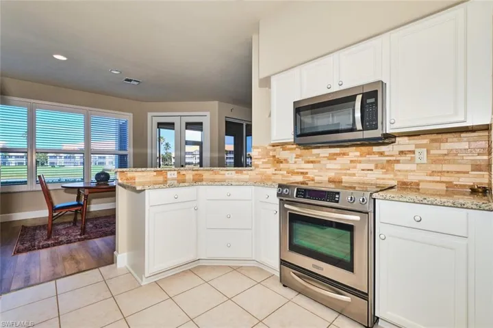 Kitchen featuring stainless steel appliances, a peninsula, light tile patterned floors, tasteful backsplash, and recessed lighting