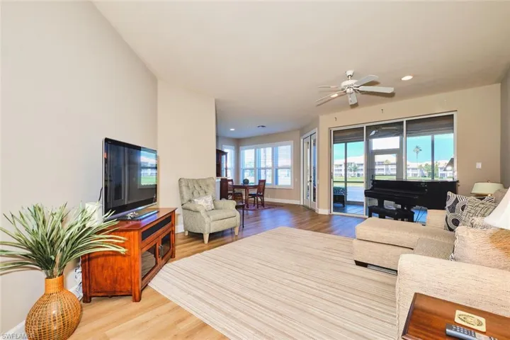 Living area featuring wood finished floors, baseboards, recessed lighting, and a ceiling fan