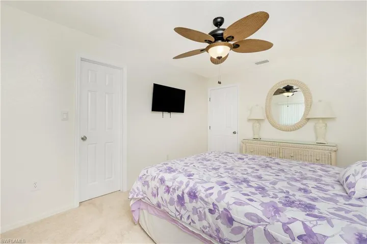 Bedroom with light carpet and a ceiling fan