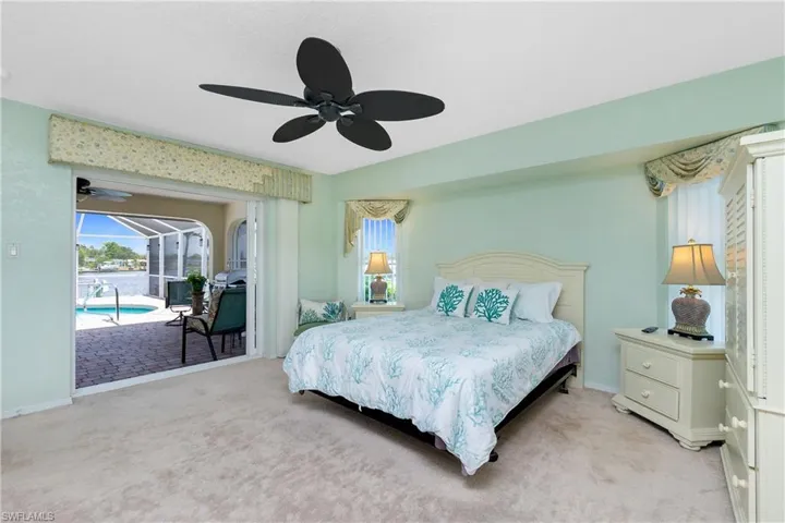Bedroom with light carpet, access to exterior, and a ceiling fan