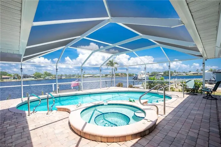 View of pool with a patio, a water view, and a lanai