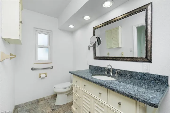 Bathroom featuring vanity, stone tile floors, and recessed lighting