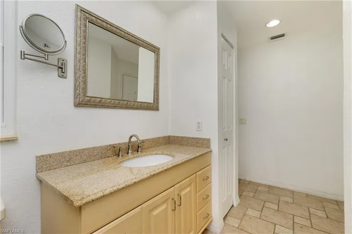 Bathroom with vanity, stone tile flooring, and recessed lighting