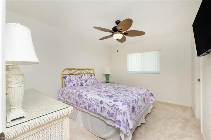 Bedroom featuring light colored carpet and a ceiling fan