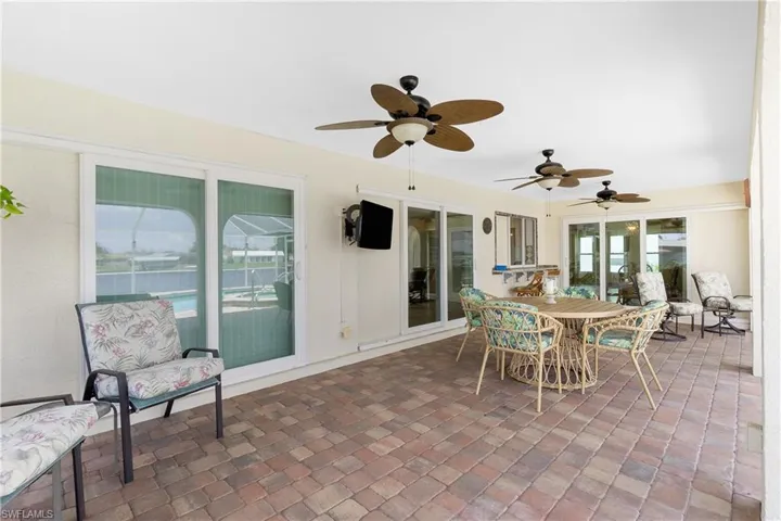 Sunroom featuring ceiling fan and outdoor dining area