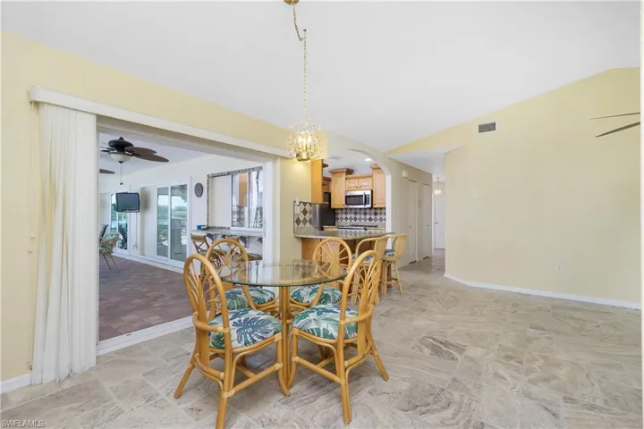 Dining room featuring ceiling fan, vaulted ceiling, and arched walkways