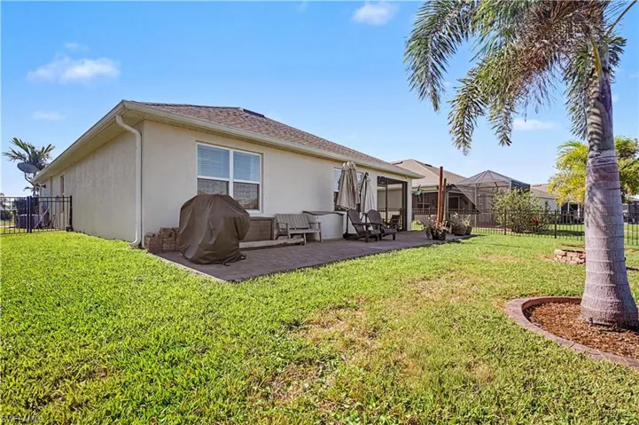 Back of house featuring a fenced backyard, stucco siding, and a patio area