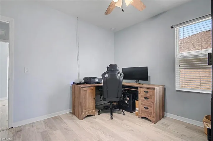 Home office with light wood finished floors and a ceiling fan