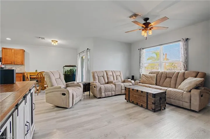 Living room with ceiling fan and light wood-style floors