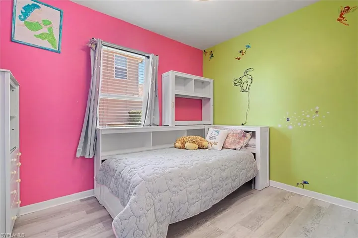Bedroom with light wood finished floors and baseboards