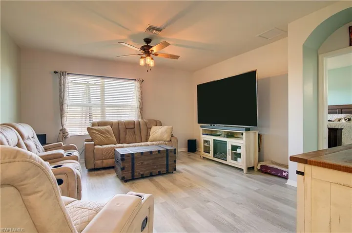 Living area featuring light wood-type flooring and a ceiling fan